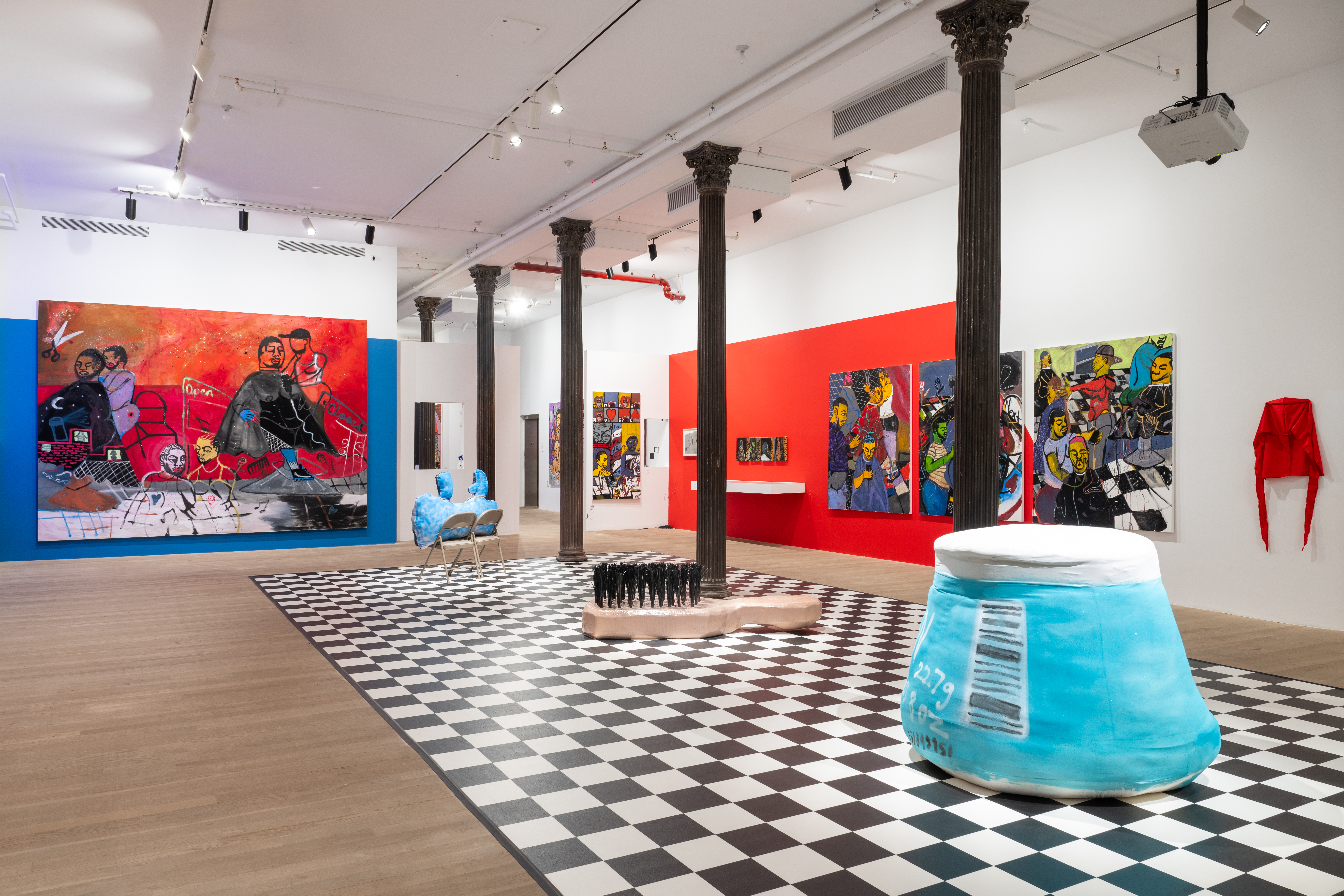 A color image of a gallery space, taken from a wide angle. There is a checkerboard floor, with three large sculptures placed down the center. A large red painting is hung on the left wall. On the right wall are a series of paintings and durags.