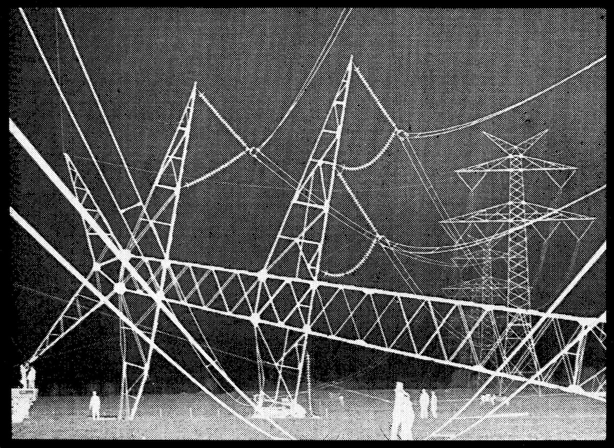 Large structures of power lines are visible with white human figures moving around in the bottom section of the image.