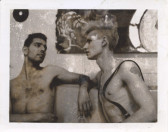 A greyscale Polaroid of two shirtless men looking into each other's eyes.