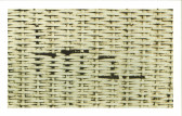 A photograph of a mat made of a beige wicker-like material.