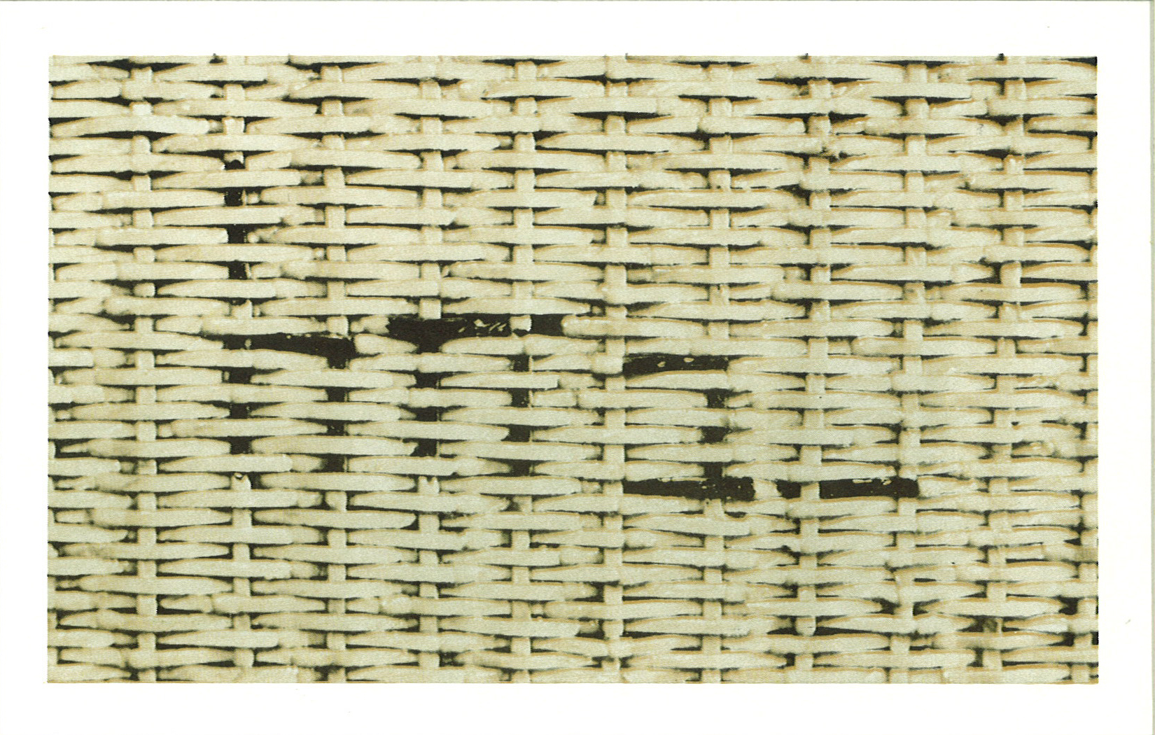 A photograph of a mat made of a beige wicker-like material.