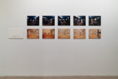 Ten photographs are displayed on a white gallery wall. The photographs are arranged into two identical rows. The photographs along the top are darker and cool toned. The photographs along the bottom are much brighter and warm toned. To the left of the photographs is a white panel that shows the floor plan of a gallery.