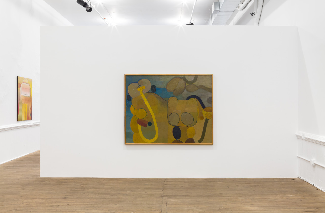 A painting with blue, yellow, and neutral tones is hung on a white wall. Another painting is visible in the background with bright yellow and orange hues.