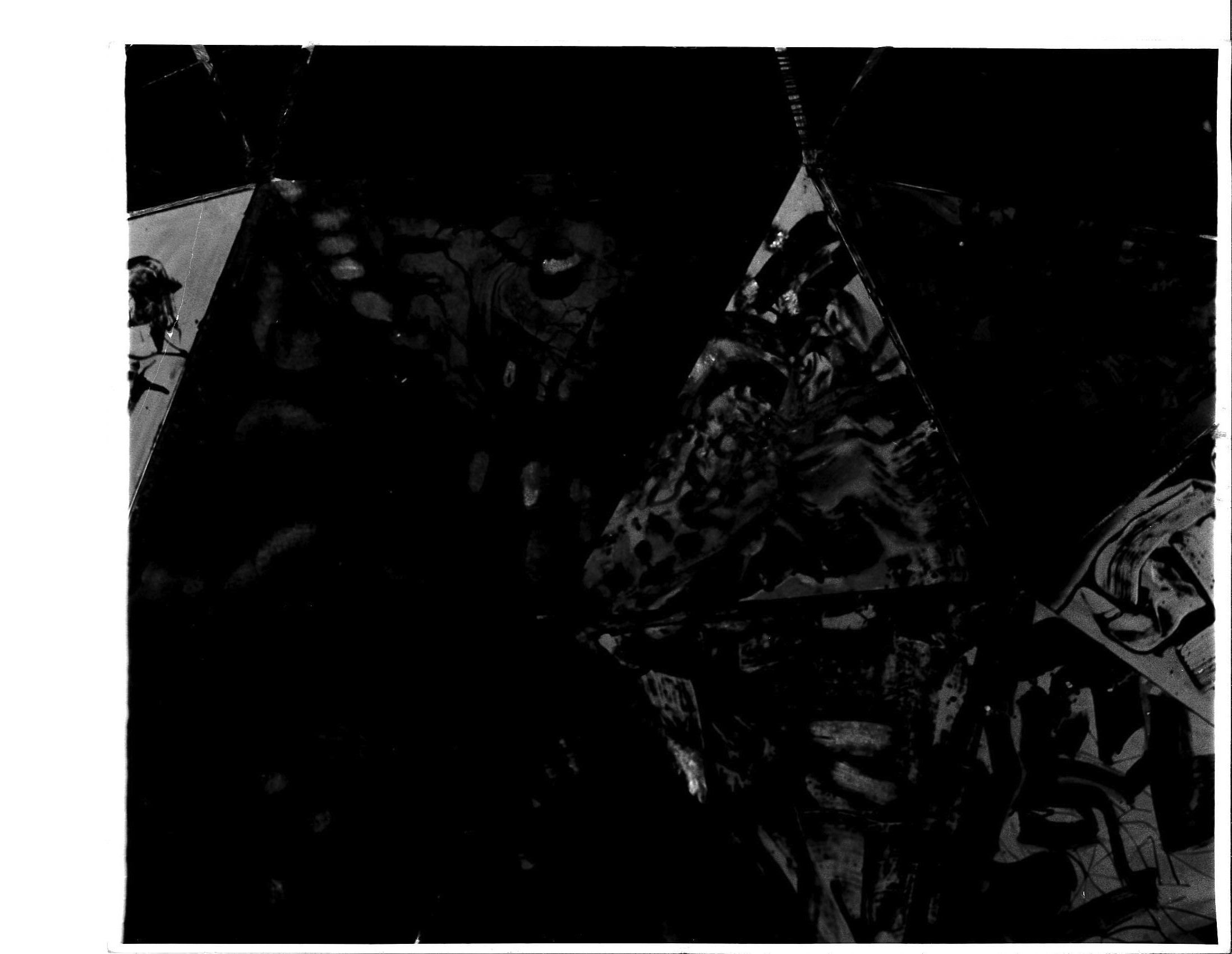 A dark black and white photograph with various shadows visible.