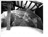 A black and white photograph of a large constructed rock dome in a galelry space.