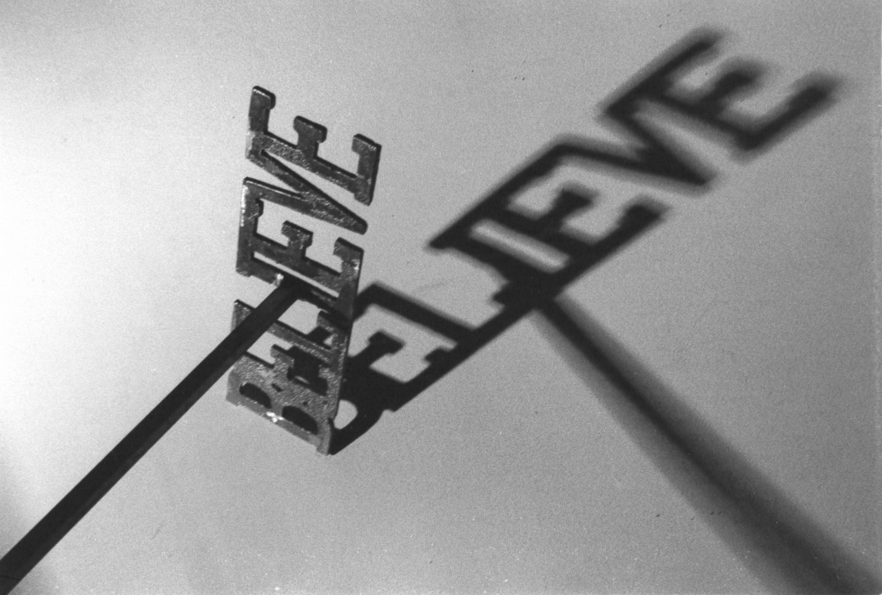 A black and white photograph of a metal rod with the word 