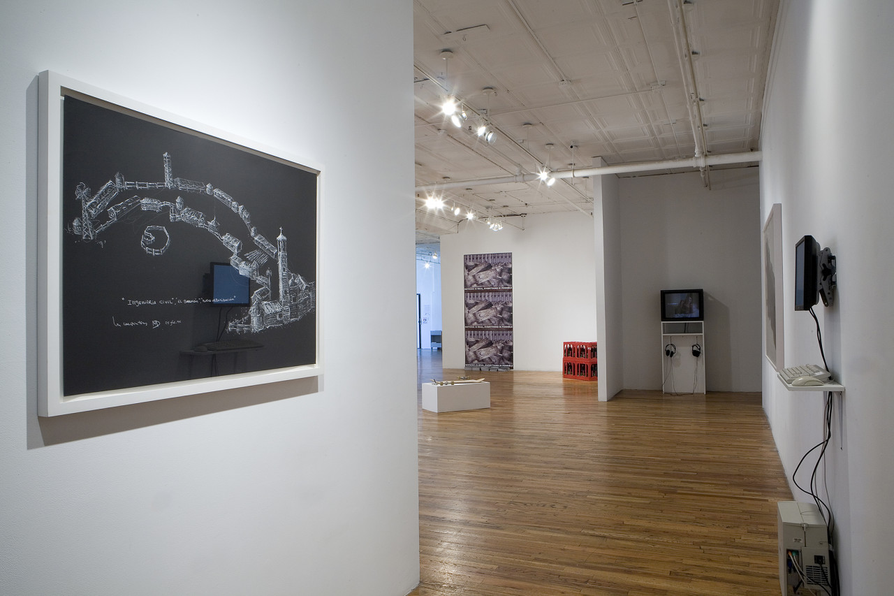 In the foreground of the installation view is a corridor wall with a  large black and white drawing of farm architecture and  in the background are monitor based works as well as sculptures of a skateboard on a pedestal and red crates of cola bottles.