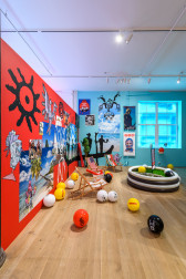 An image of a multicolored exhibition space consisting of beach paraphernalia.