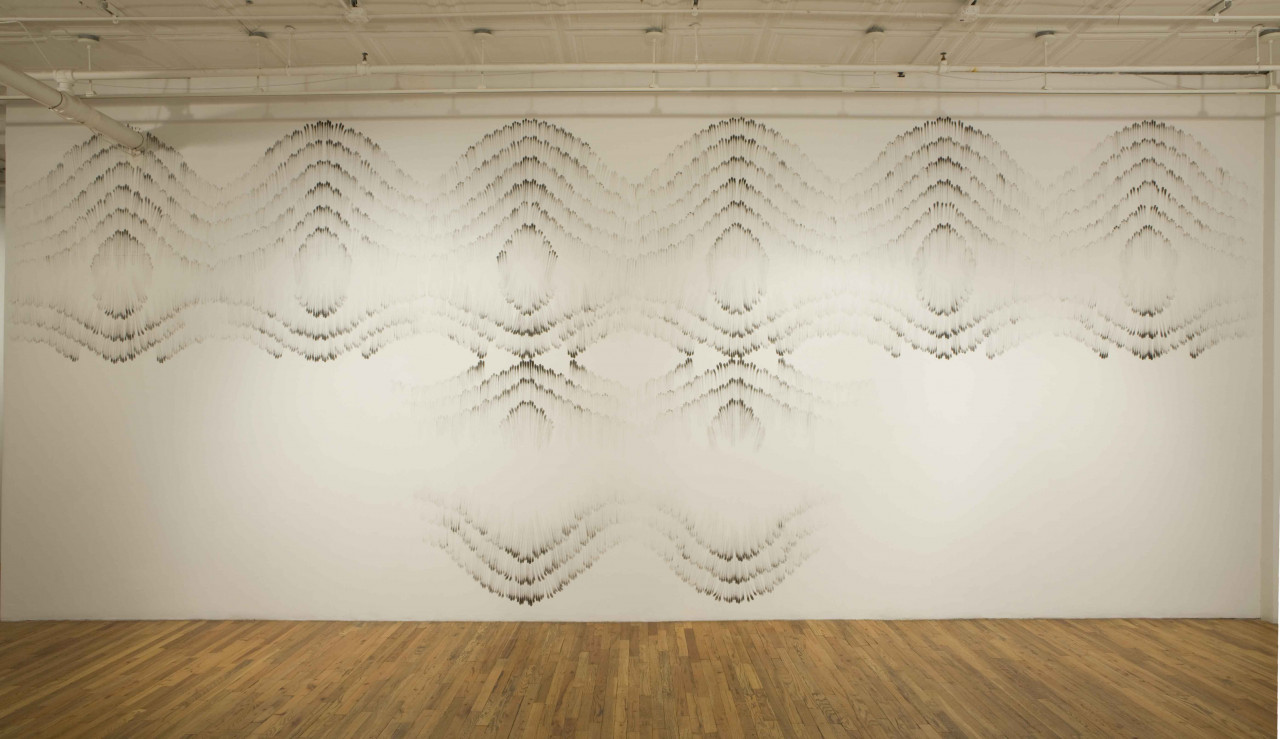 A large white wall with symmetric, geometric patterns drawn on it.