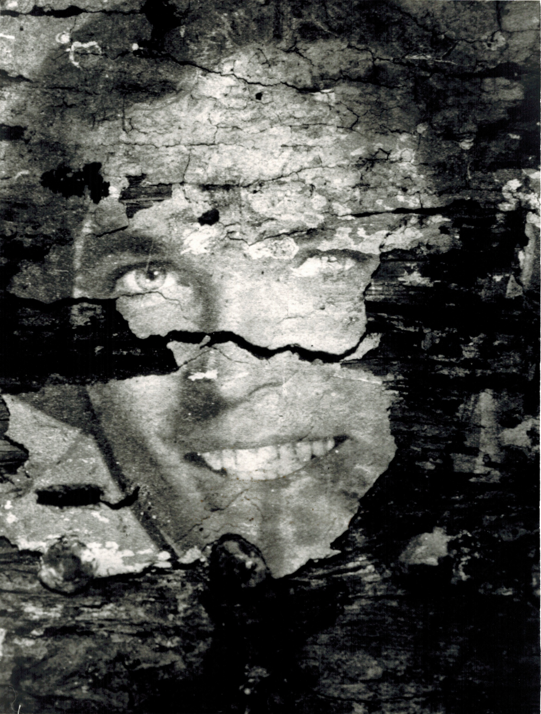 A close-up, black and white image of a face, with parts of the image chipping off and revealing a black backing.