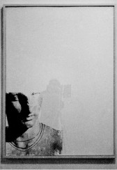 A photo of a 2D artwork consisting of a blank rectangular surface with the image of an classical sculpture bust in the lower left-hand corner.