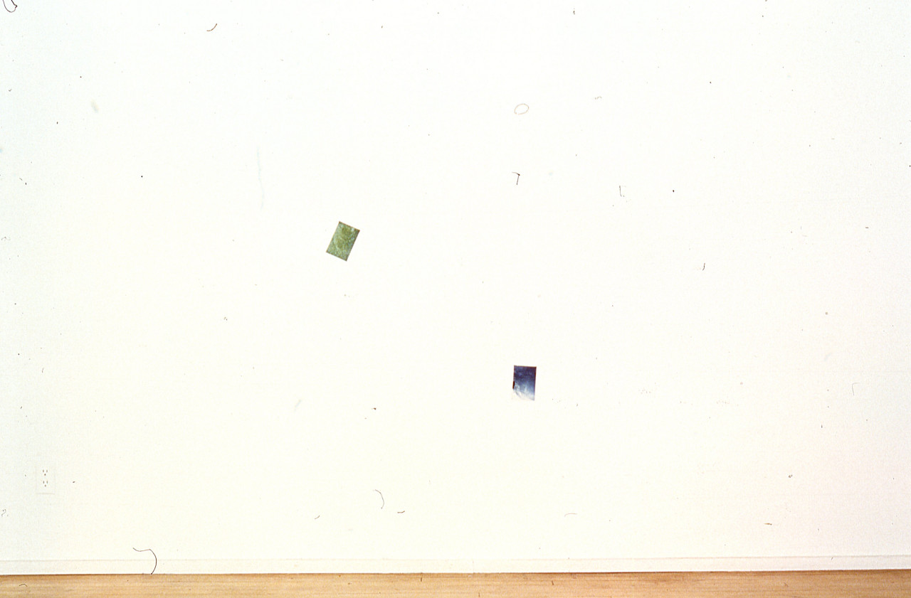 Two photographs are mounted on a white gallery wall.