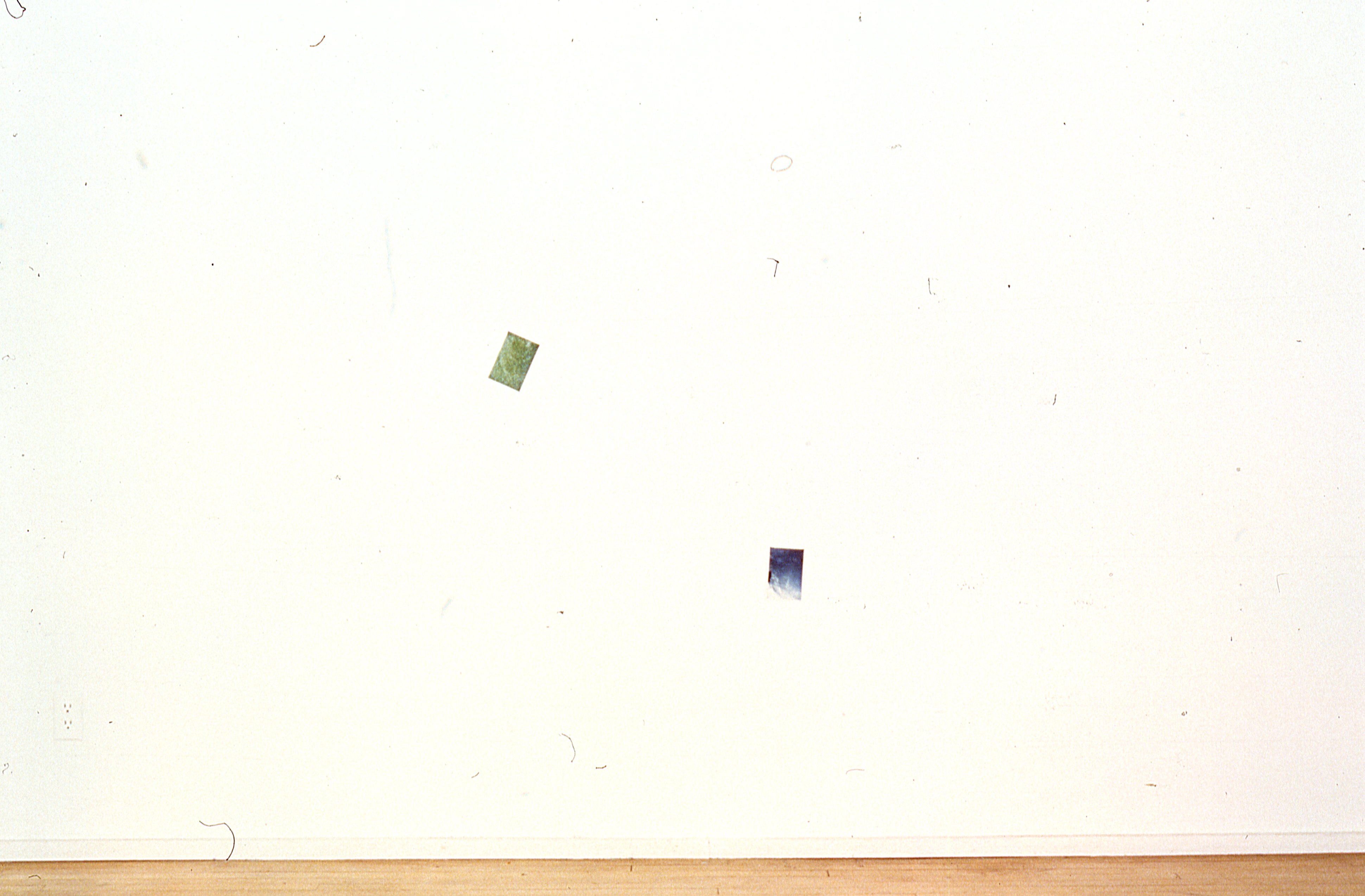 Two photographs are mounted on a white gallery wall.