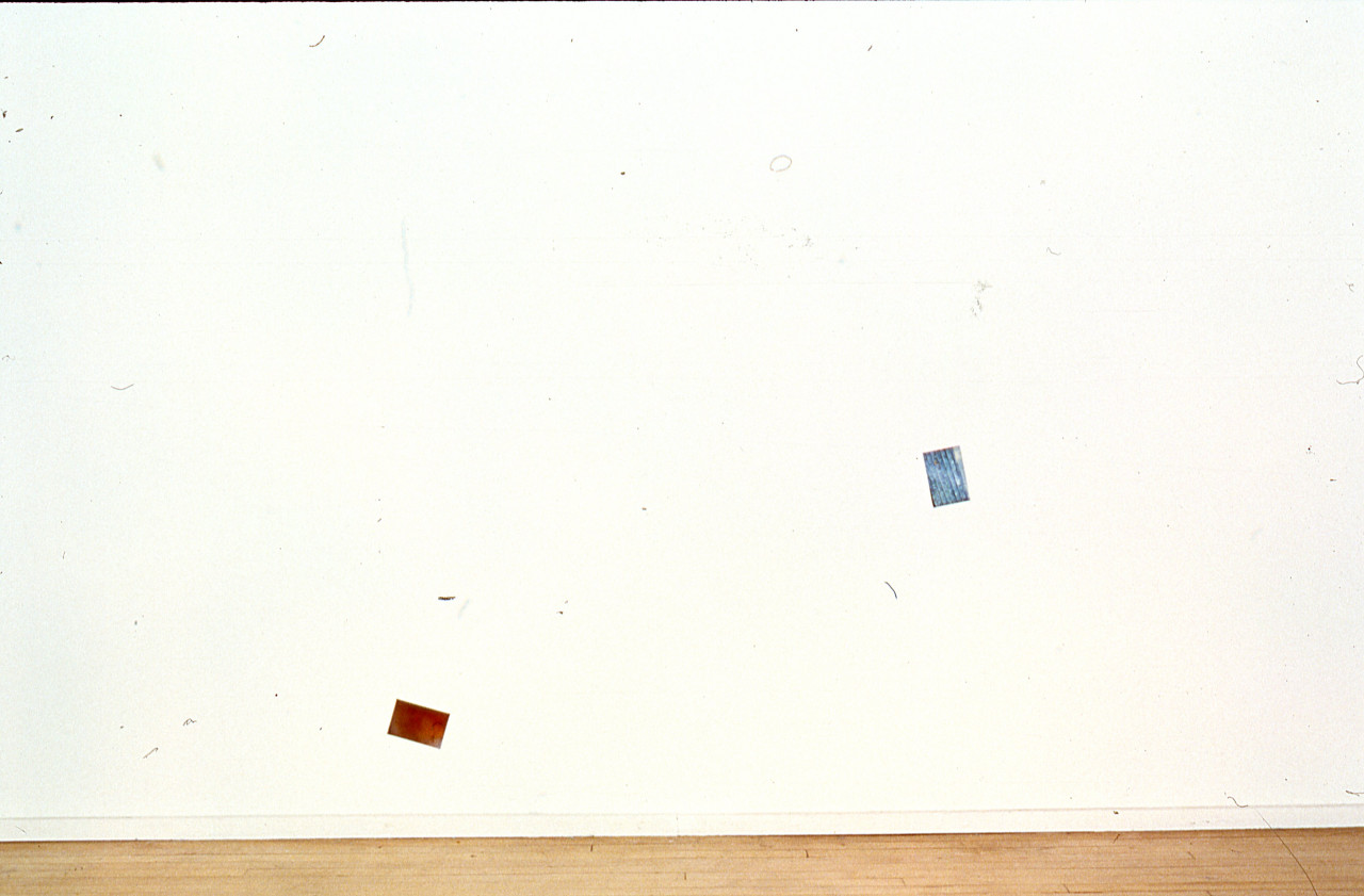 Two photographs are mounted on a white gallery wall.