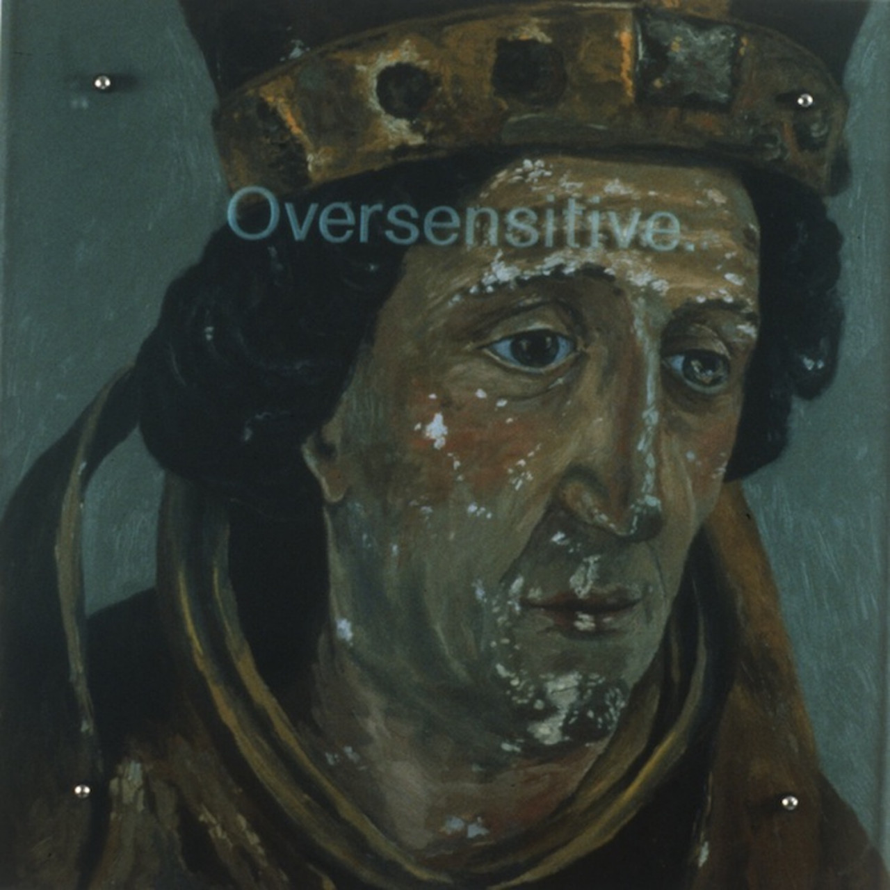 A slightly chipped painting of a face with downcast eyes and a medieval-style crown.  The word "Oversensitive" is overlaid across the top part of the face.