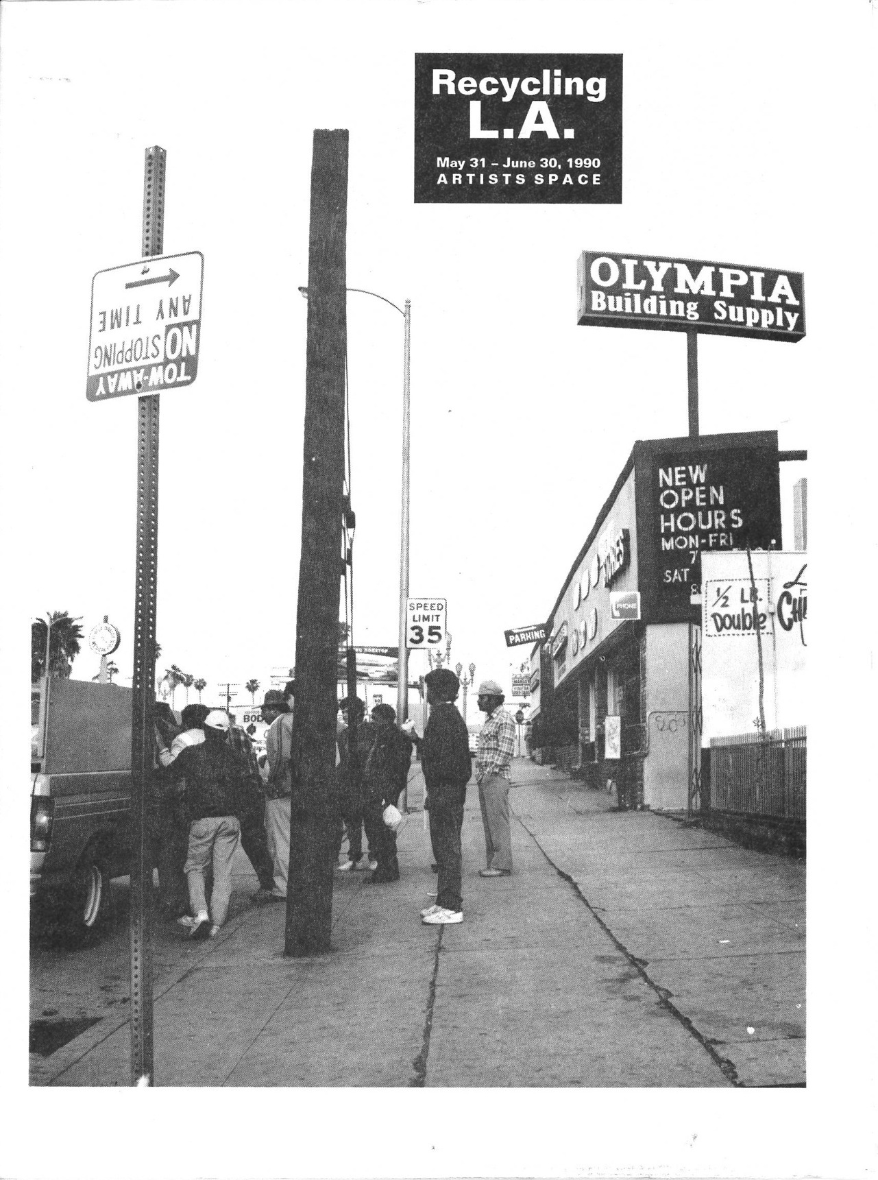 A group of people gathered on a city sidewalk, looking into a parked car.  Above them, the text 