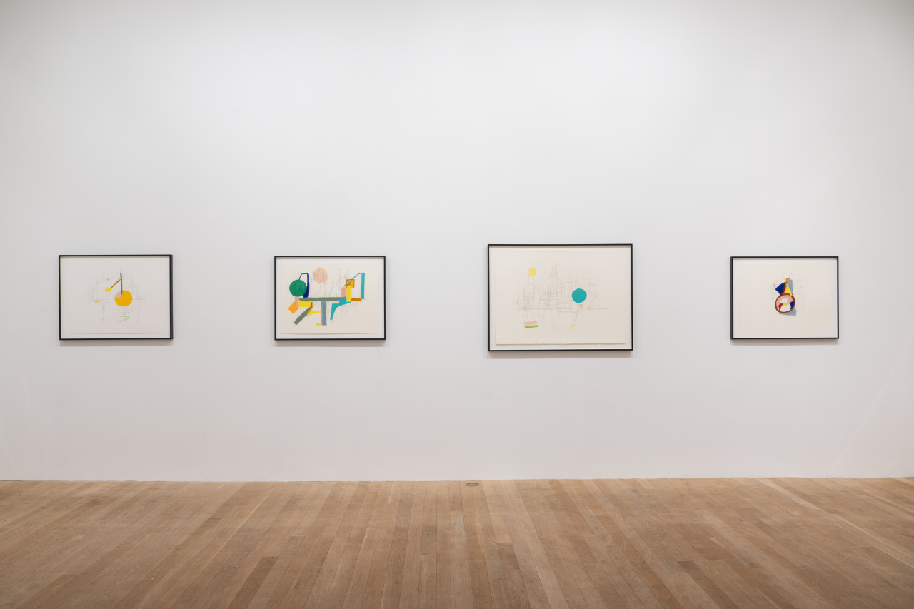 A color image of four framed works displayed against a white wall. The drawings depict abstract compositions made up of colorful shapes and lines, and pencil strokes.