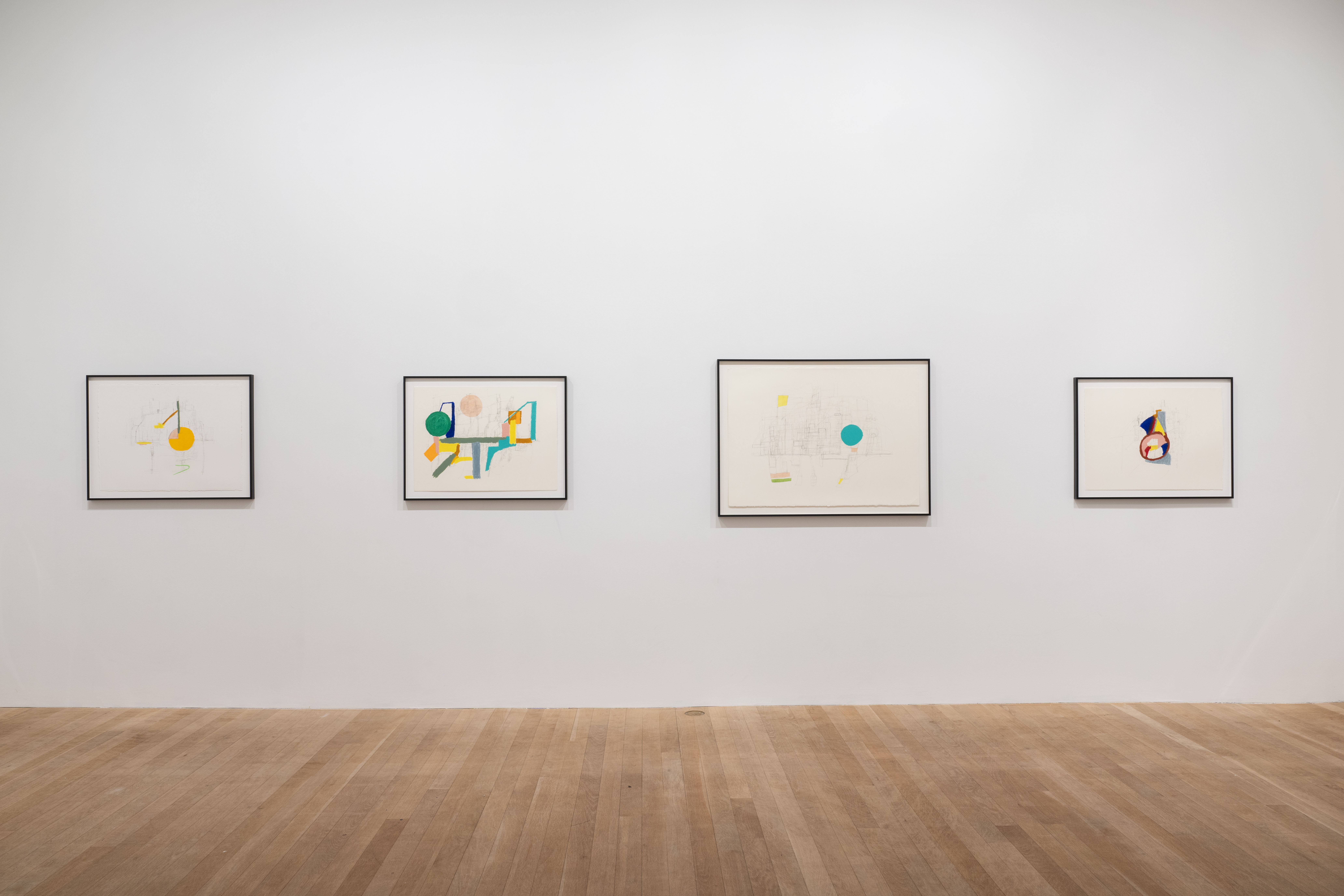A color image of four framed works displayed against a white wall. The drawings depict abstract compositions made up of colorful shapes and lines, and pencil strokes.