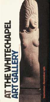 A nude statue of a woman in a headdress. To the left, sideways text reads, 