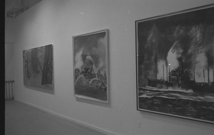 A photograph of three paintings hanging in a row on a white gallery wall.  The closest to the camera, on the right, shows a ship at sea, the center shows a fountain, and the painting on the left is an abstract composition of black diagonal lines.
