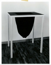Black fabric drops down from the black table top in an oval-like shape.
