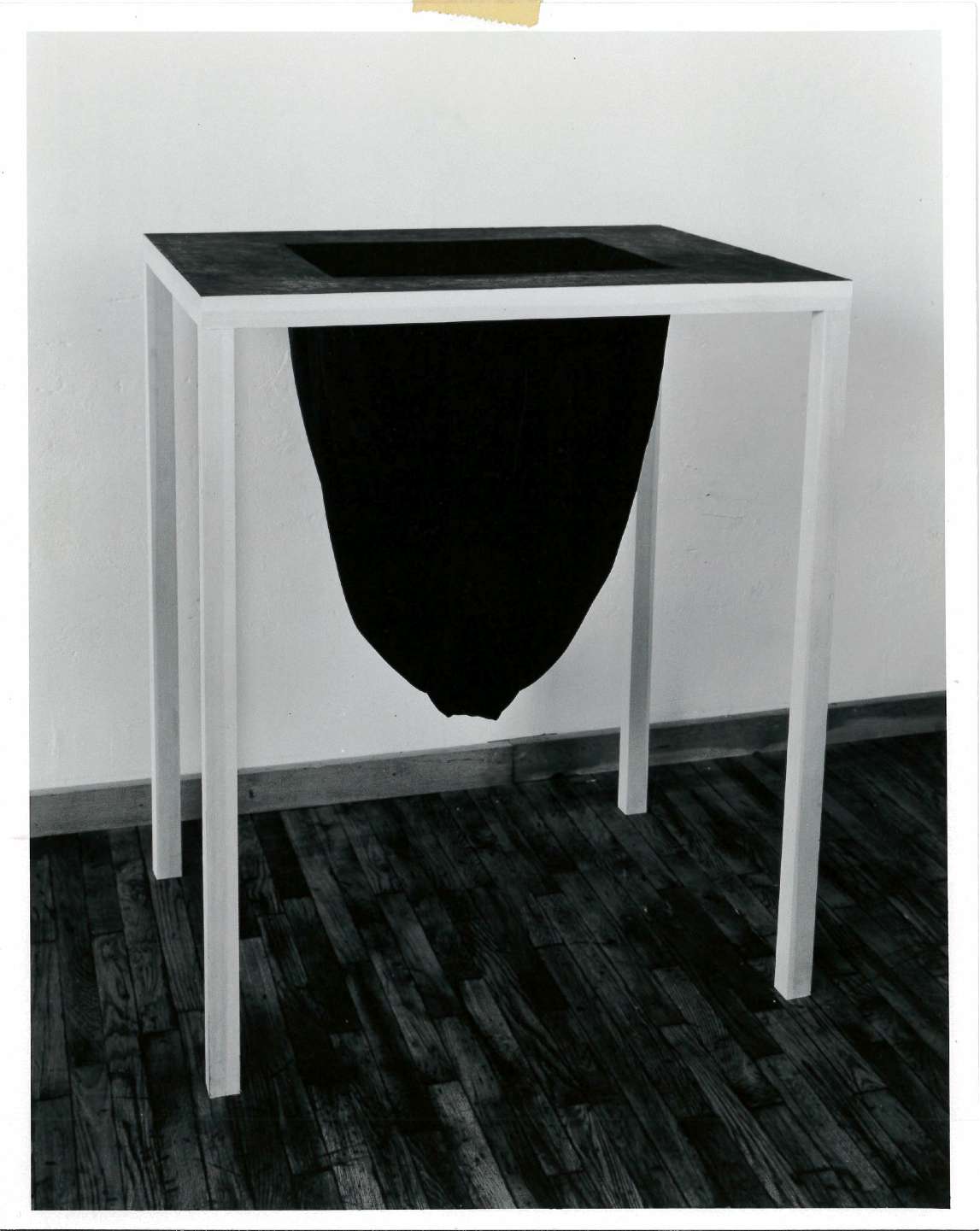 Black fabric drops down from the black table top in an oval-like shape.