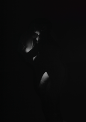 A life-size vinyl against a black wall depicting a black-and-white image of a body in motion, multiple images are overlayed on top of each other to create a ghostly atmosphere.