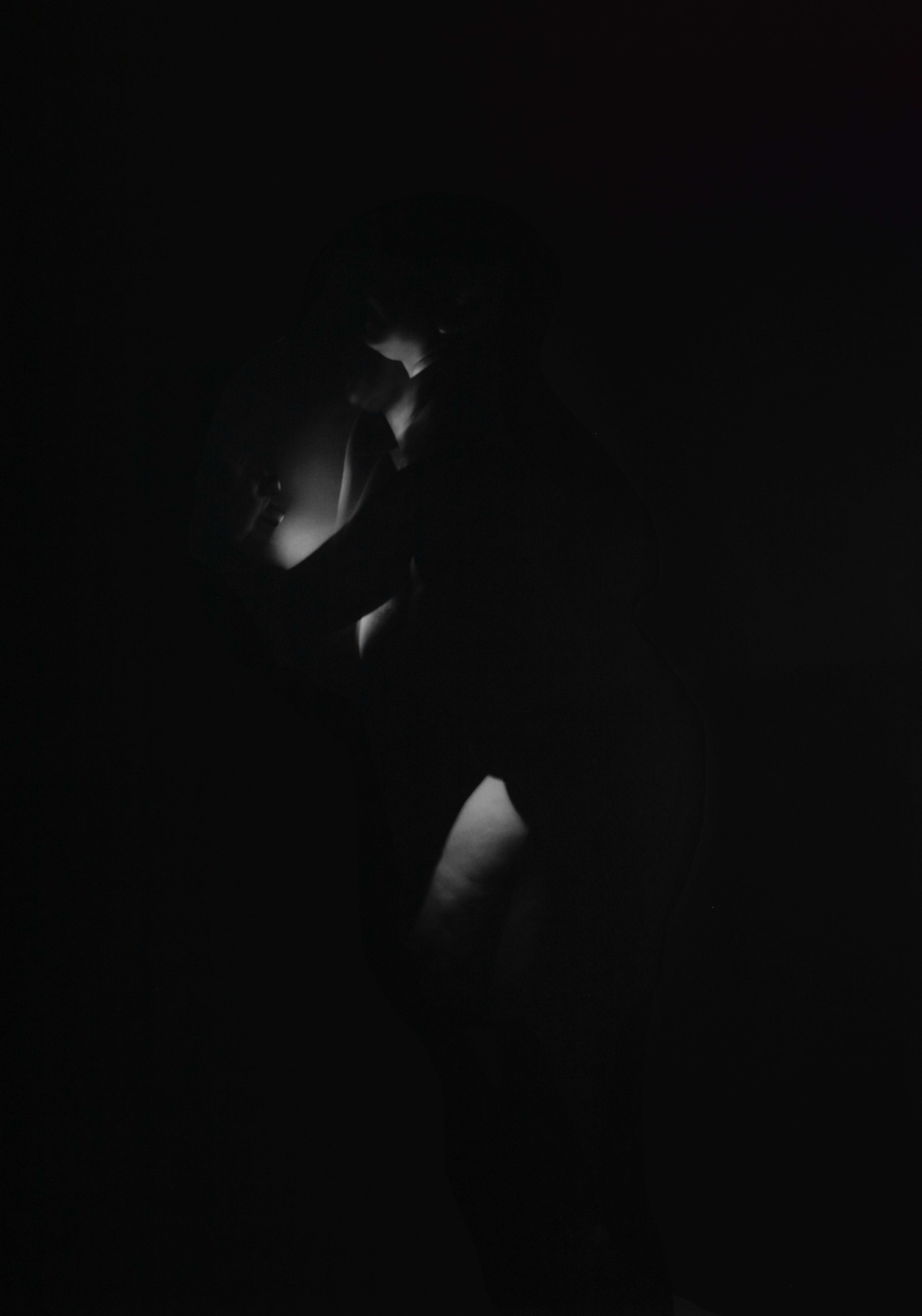 A life-size vinyl against a black wall depicting a black-and-white image of a body in motion, multiple images are overlayed on top of each other to create a ghostly atmosphere.