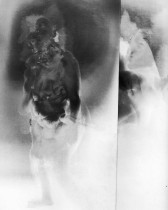 A black-and-white film still depicting a nude figure, her body is turned two-thirds of the way. Several smoky duplicates of the figure's body and face are superimposed over the original image. A cloudy and blooming, nondescript atmosphere serves as the background.