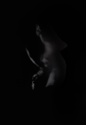 A life-size vinyl against a black wall depicting a black-and-white image of a body in motion, multiple images are overlayed on top of each other to create a ghostly atmosphere.