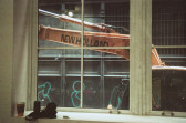 A window sill with cups, cans and cloth is visible and a crane can be seen outside of the window with the text: 