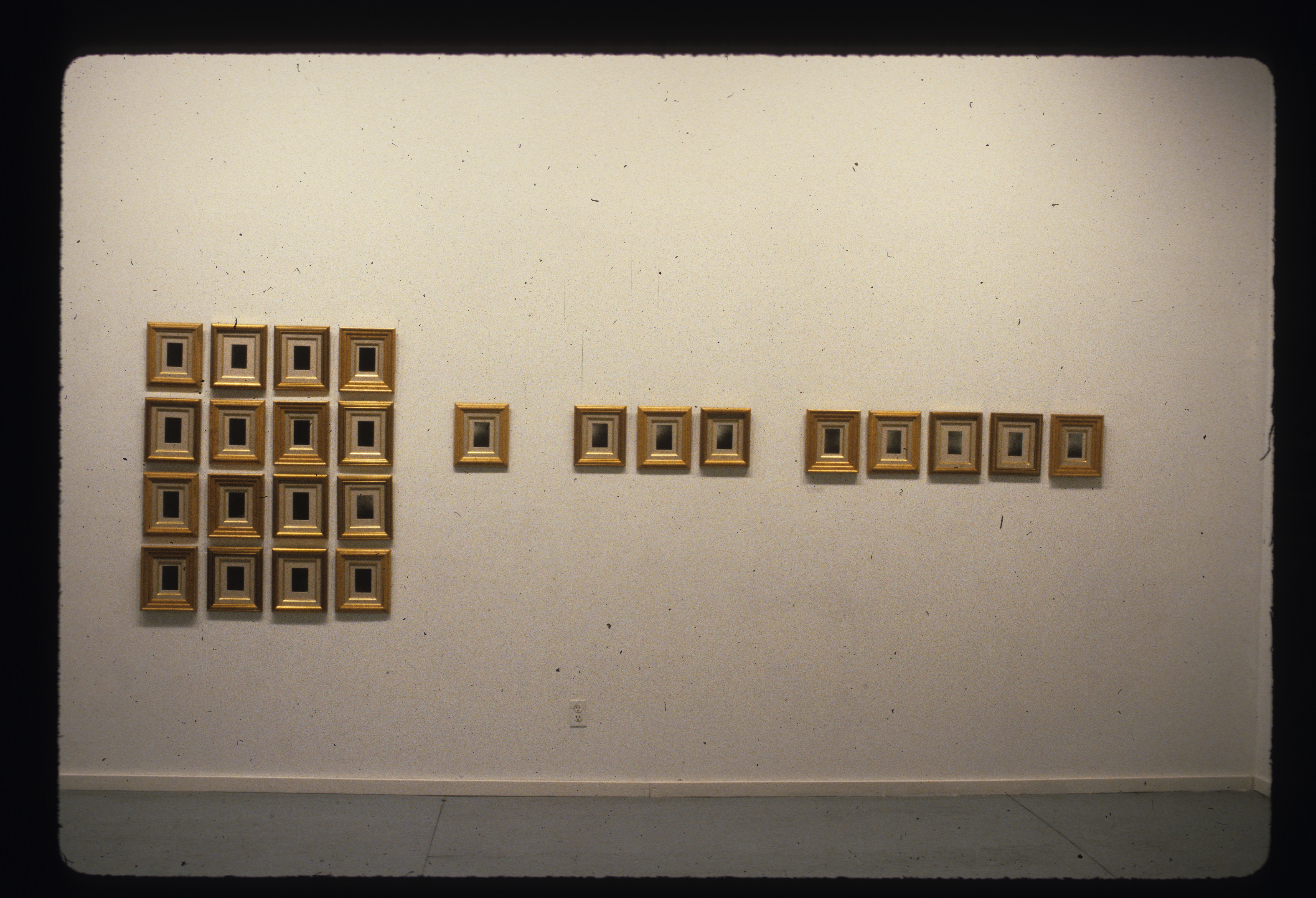 A number of framed images appear on the wall, on the left there is an organized section of 16 and 8 are hung horizontally next to that grouping.