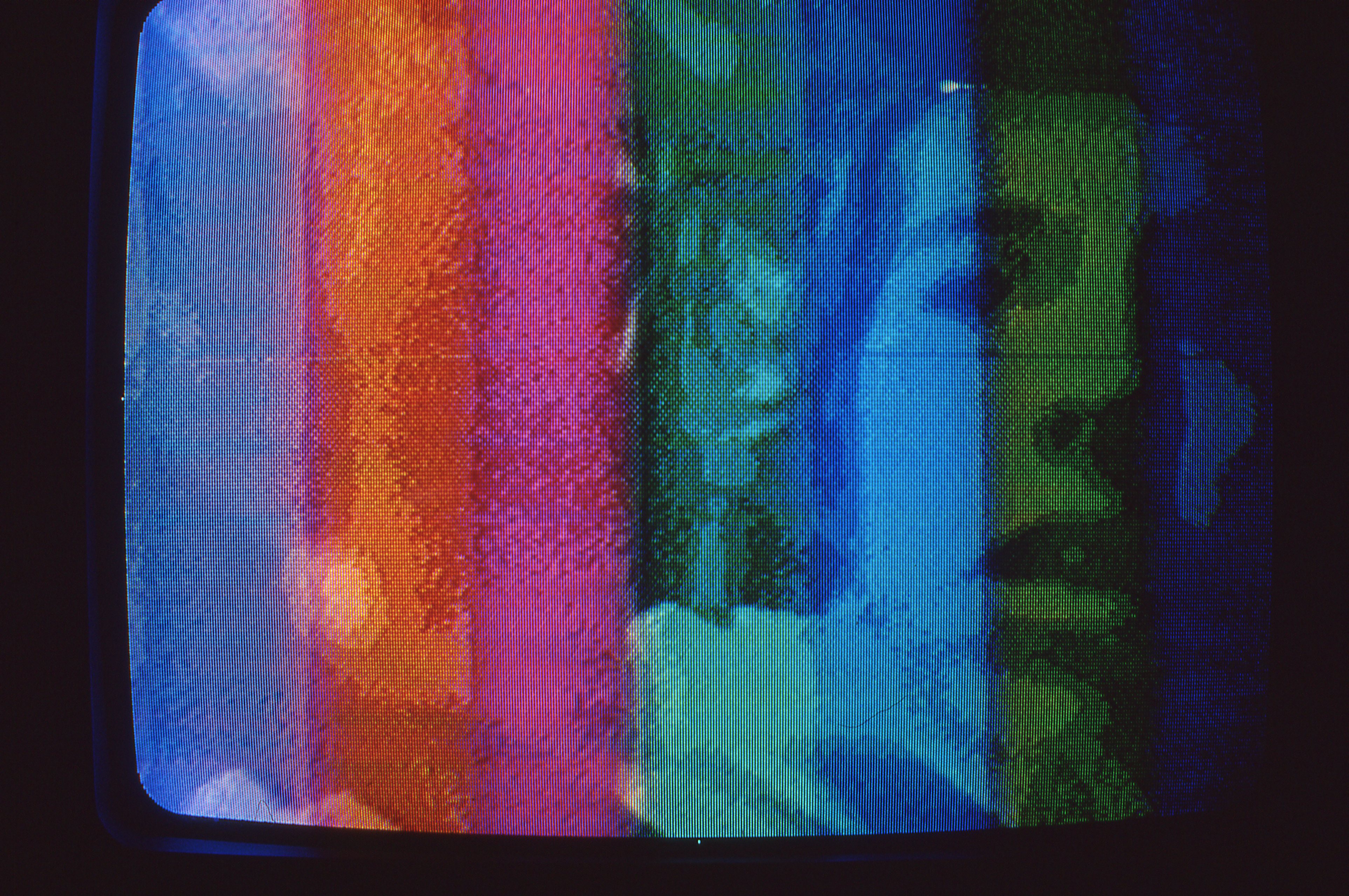 A grainy image of a person's face in striped tones of blue, orange, pink, and green.