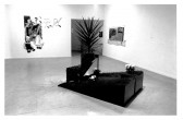 A piece of landscaping appears on the gallery floor with flowers and plants coming up from it in a stair-like fashion. Paintings appear in the background in a white-walled gallery space.
