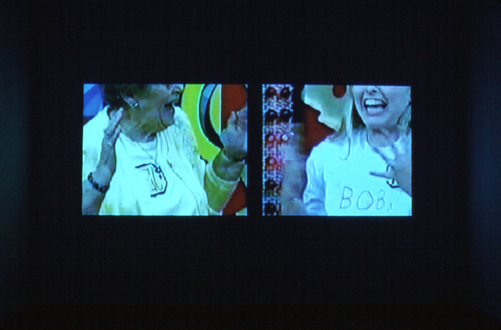 A split screen of two people, each visible between their nose and their chest. Both are extremely excited, with their hands raised up.