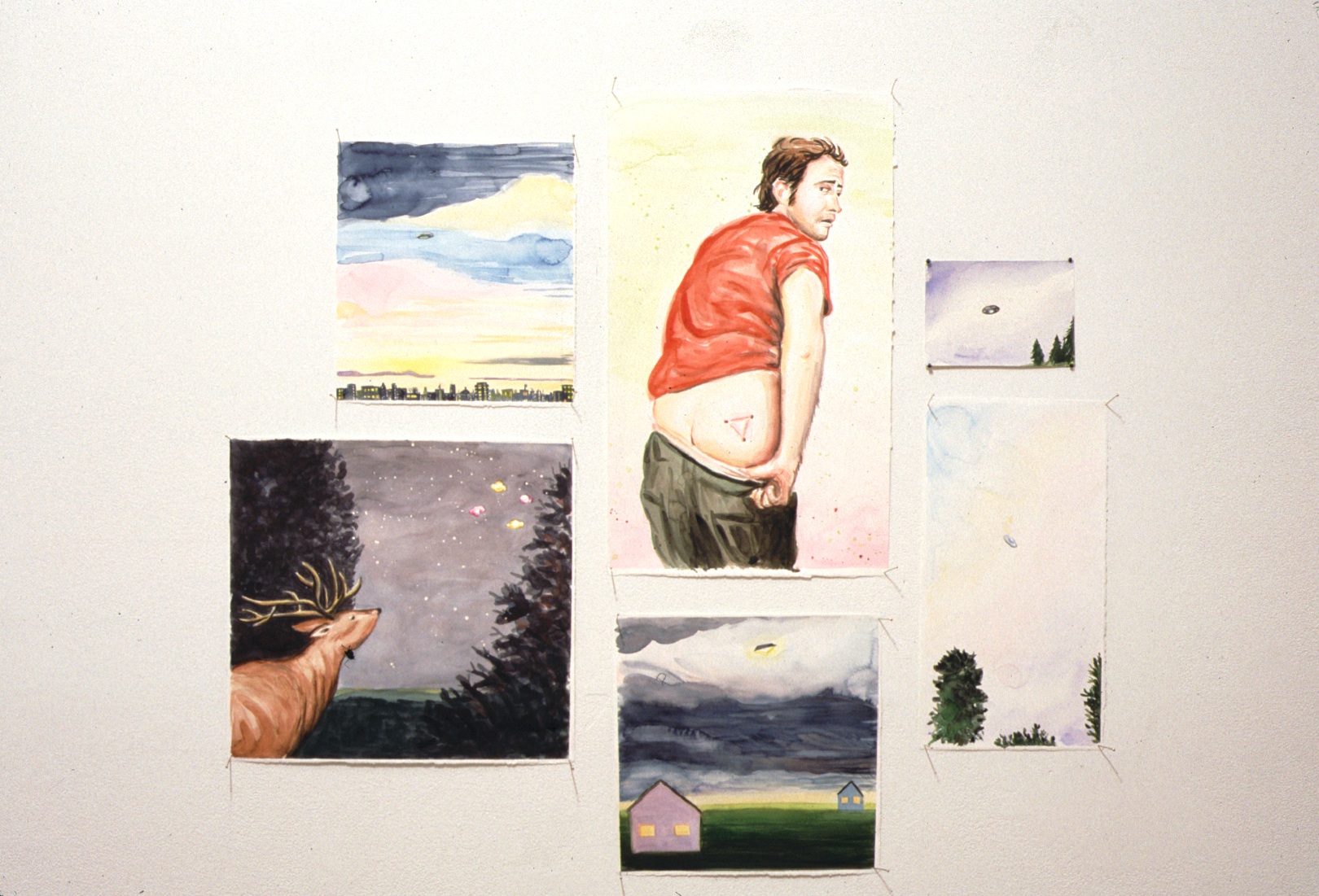 Six watercolor paintings affixed to a white wall with pins. The paintings are various sizes, five depicting the sky and landscapes at various times of day. In the center, a man is depicted facing backwards, pulling down his pants to expose a tattoo of a triangle.