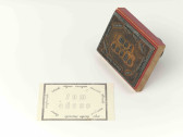 A rubber stamp sits to the right of a postcard, against a white background. The design on the rubber stamp reads 