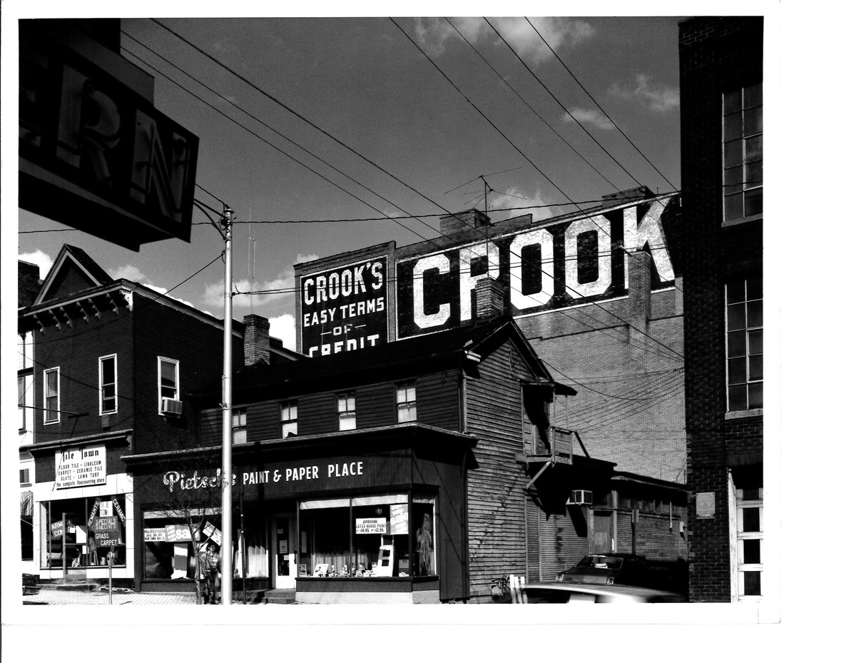 An image of a town setting with advertising on a building that reads, 