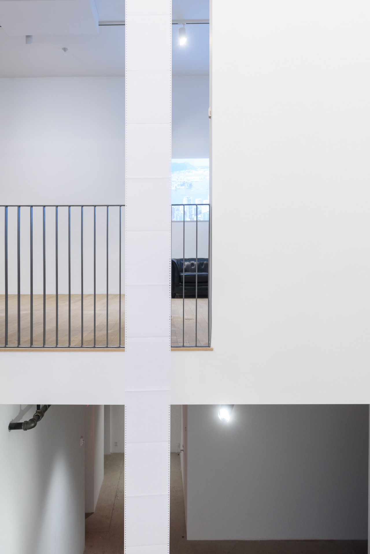 A long sheet of white paper is suspended across multiple floors. Handrails for the second floor are visible in the background.