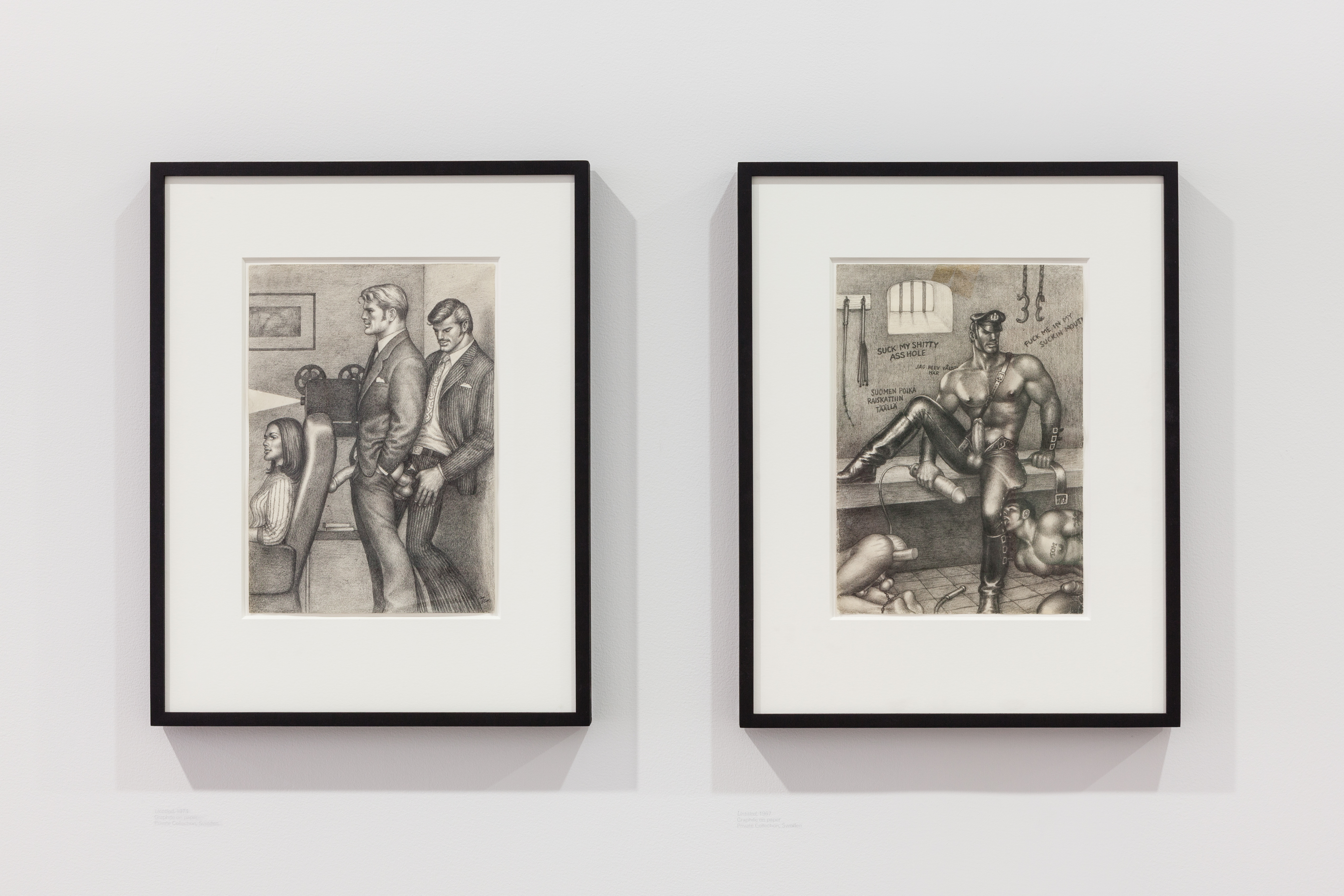 Two illustrations framed on a wall. On the left, two men, dressed in suits, engage in intercource behind a women sat in a chair. On the right, a half naked man sits on a bench in a cell above a man licking his leg, and an exposed butt that is plugged.