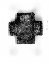Sculpted cross with strings strapped around it, holding unidentified items together inside of it. Held on a white background with dimensions written in pencil on the right side.