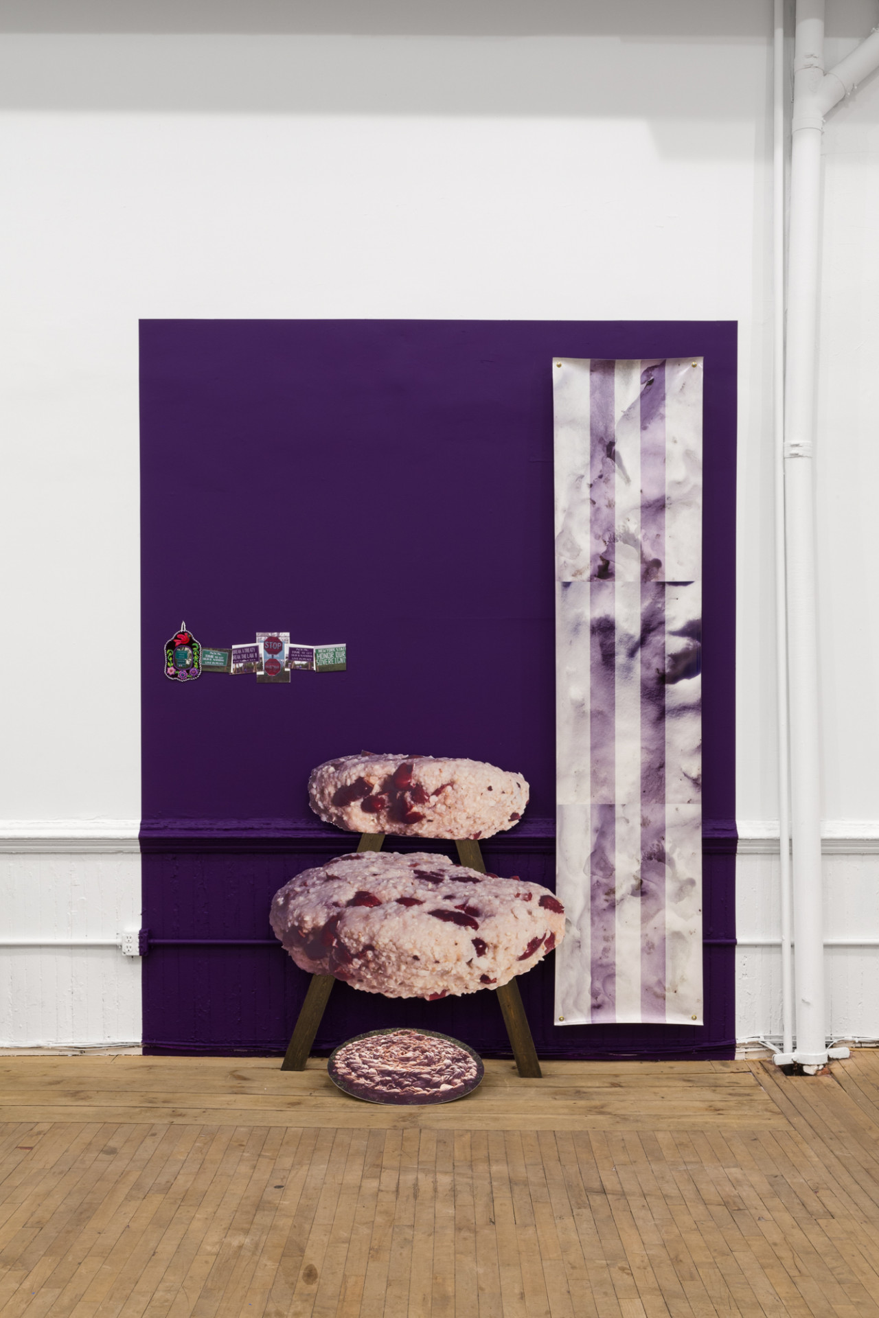 A purple square on a white wall with various photographic media displayed.
