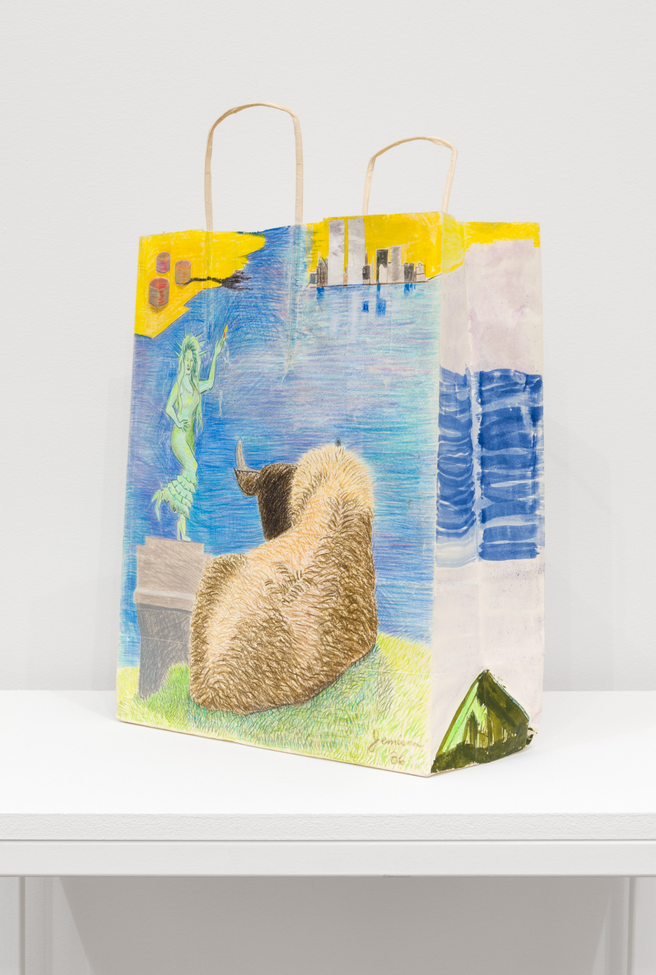 A handled paper bag, placed at an angle, with detailed illustrations along the sides. The front image depicts a goat sitting on grass with its back turned to the viewer, facing a dancing Statue of Liberty against a blue background. In the right corner is a small drawing of the twin towers against a yellow background, and in the right corner is a small drawing of three small cylinders with smoke emanating from one. The side panel has paintlerly blue  stokes in the middle, and a small green triangular tent at the bottom.