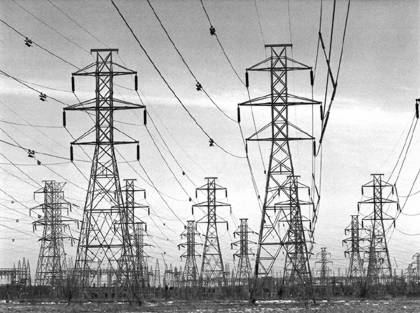 A black and white image of electrical towers stretching into the distance.