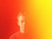 An overexposed image of a person looking at the camera, their face partially obscured by the exposure.