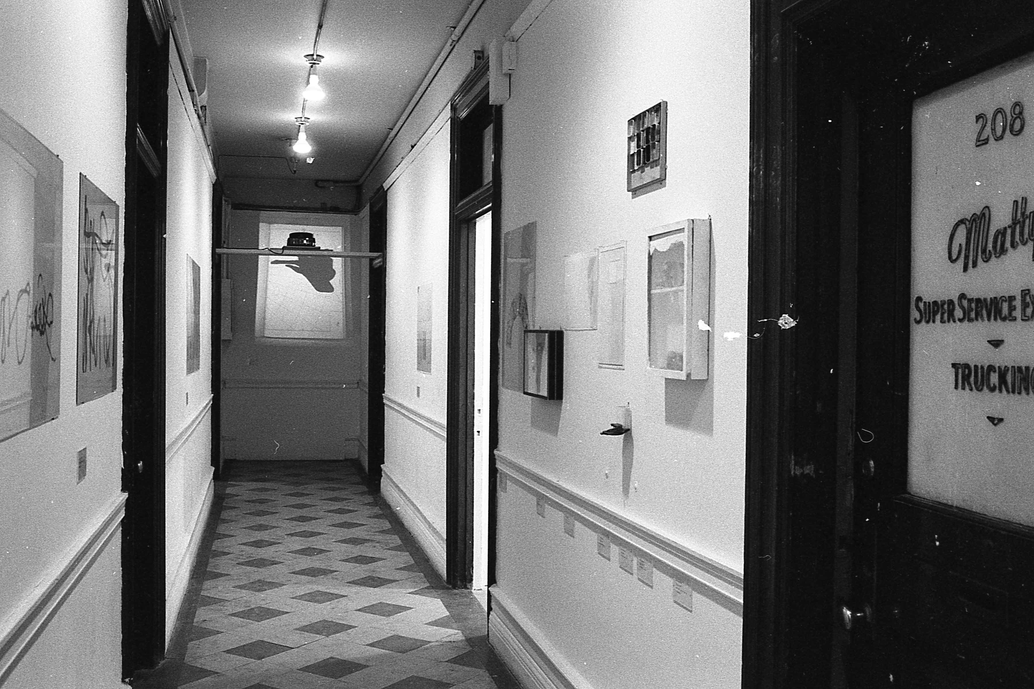 View down a hallway with framed images on the wall.