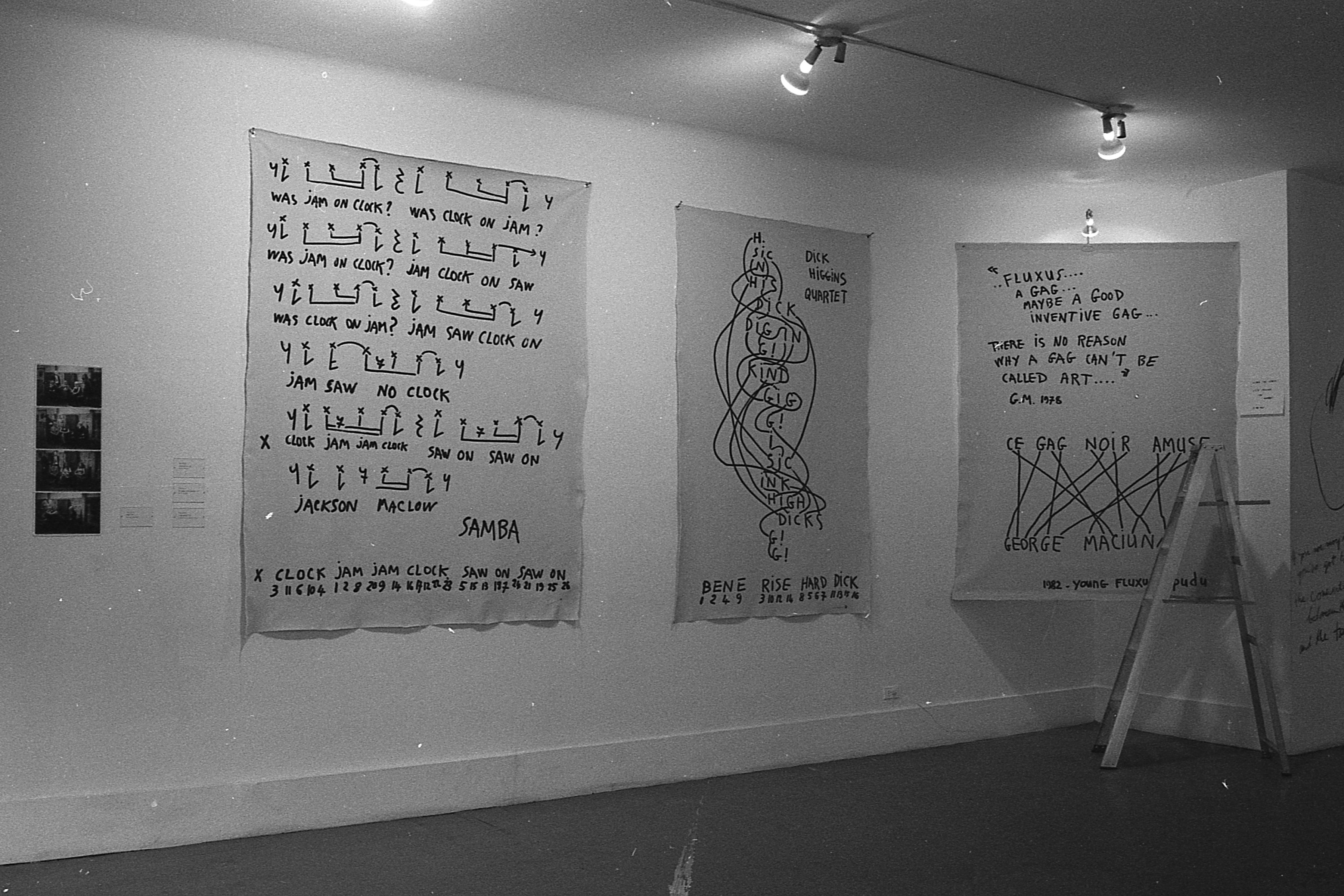 Three large wall text pieces appear in a white-walled gallery space.