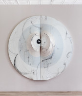 Two half-circle canvases, positioned together to create a full circular shape, displayed on a light mauve wall. The canvases are filled with neutral blue and pale pink colors as well as sweeping, black line illustrations. At the center of the composition, the canvases stretch outward in mirrored c-curve shapes.