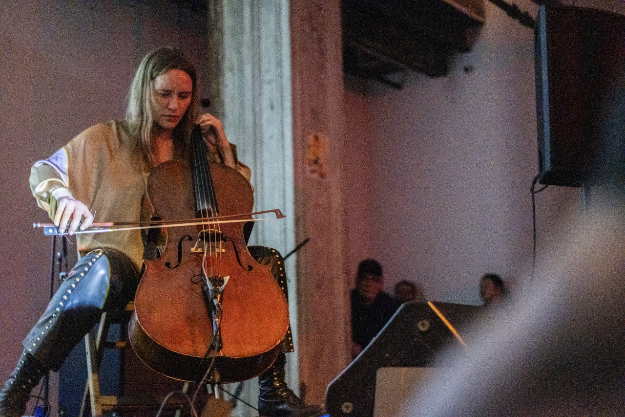 A performer plays the cello on stage.
