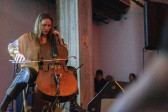 A performer plays the cello on stage.